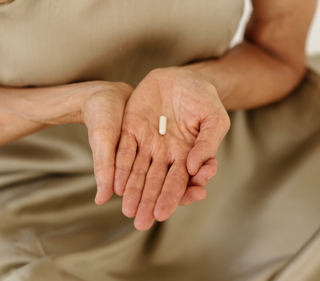 Person holding a single supplement capsule in one hand, emphasizing simplicity in nutrition.